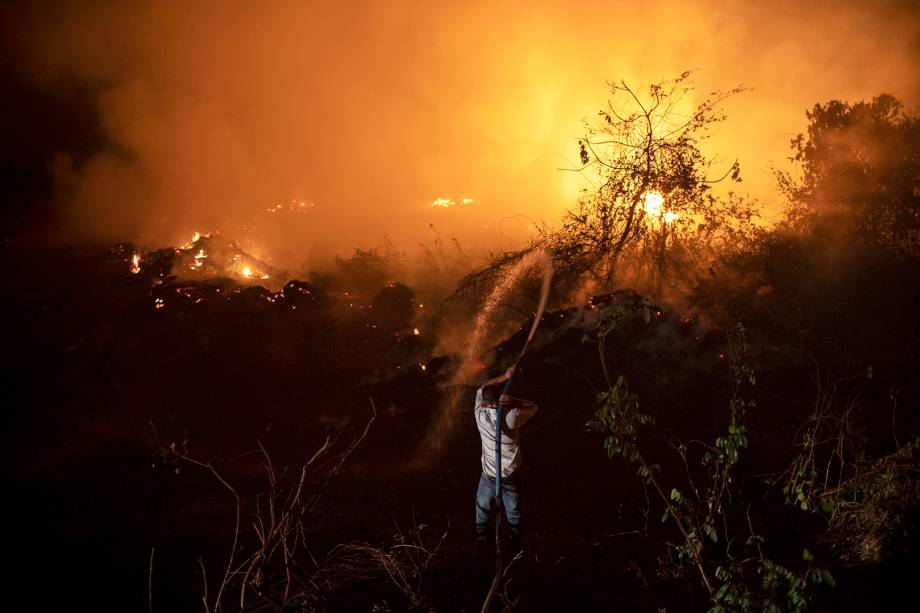 TRANSPANTANEIRA Voluntários tentam apagar o fogo em uma das 119 pontes da madeira da região, no Mato Grosso