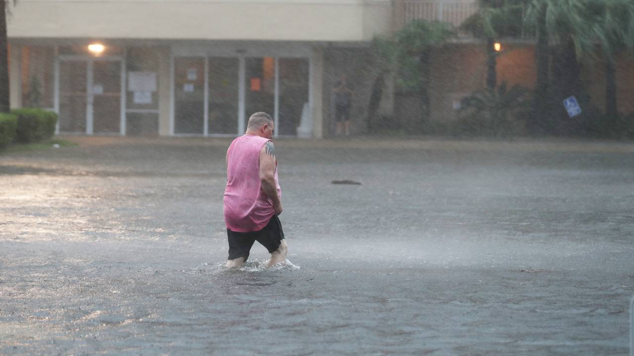 Homem anda em rua alagada pelo furacão Sally em Gulf Shores, Alabama. 15/08/2020