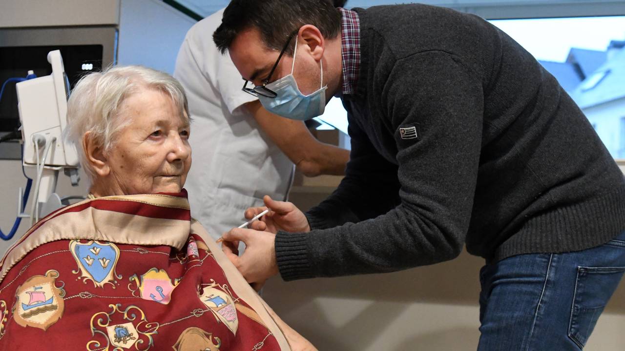 French doctor Francois Lancelot administers a dose of the Pfizer coronavirus disease (Covid-19) vaccine to a Ehpad resident, on January 4, 2021 in Saint-Renan, western France. - French president faced on January 4, 2020 growing pressure to accelerate France's Covid-19 vaccination drive which has seen just a few hundred people receive the jab. (Photo by Fred TANNEAU / AFP)