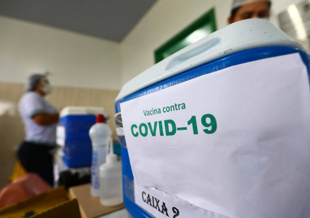 INÍCIO - O programa começou com a enfermeira Mônica (acima), ao lado de Doria, e se espalhou por cidades como Rio (foto maior) e Florianópolis: só no Brasil a largada da vacinação representou uma derrota política para o presidente -