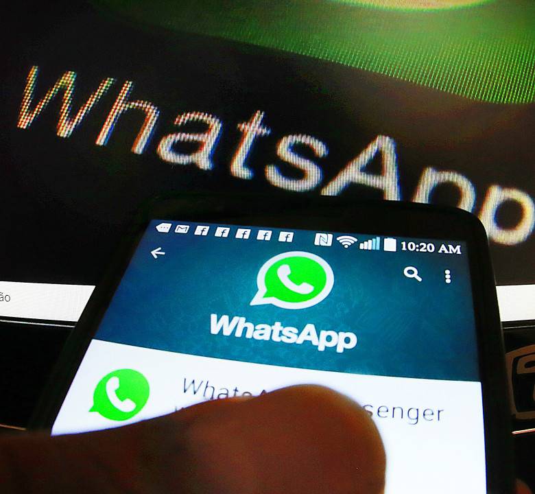 Golpes que usam a vacinação contra a Covid-19 se espalham pelo país. Pessoa acessando o aplicativo de mensagens WhatsApp. Na imagem uma pessoa segurando um celular com o aplicativo whatsapp aberto.