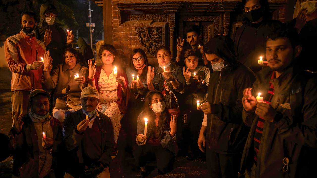 KATHMANDU, NEPAL - 2021/03/31: Protesters holding burning candles while making the three-finger salute attends a candlelight vigil for those who died in protests during Myanmar's military coup at the Premises of Basantapur Durbar Square, a UNESCO world heritage site.Protest against the military coup and the ongoing violence in Myanmar. (Photo by Prabin Ranabhat/SOPA Images/LightRocket via Getty Images)