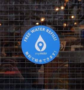 Adesivo do programa mymizu em porta de um café em Tóquio que sinaliza um ponto de abastecimento de garrafinhas d’água Adesivo do programa mymizu em porta de um café em Tóquio que sinaliza um ponto de abastecimento de garrafinhas d'água