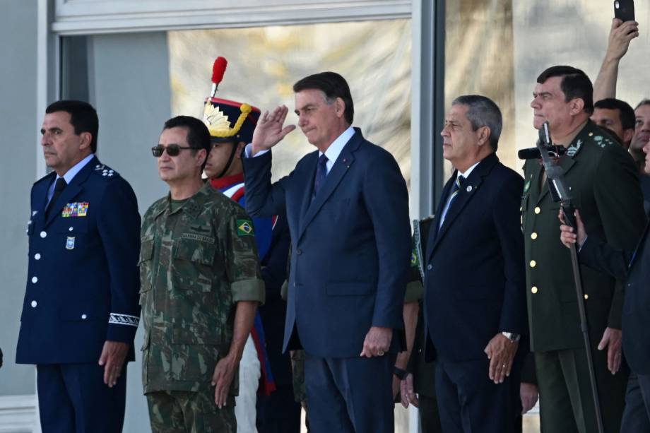 Jair Bolsonaro acena ao lado do comandante da Aeronáutica Carlos de Almeida Baptista, do comandante da Marinha Almir Garnier, do ministro da Defesa, Braga Netto, E do comandante do Exército, Paulo Sergio Oliveira (E/D), durante o desfile dos veículos militares em frente ao Palácio do Planalto -