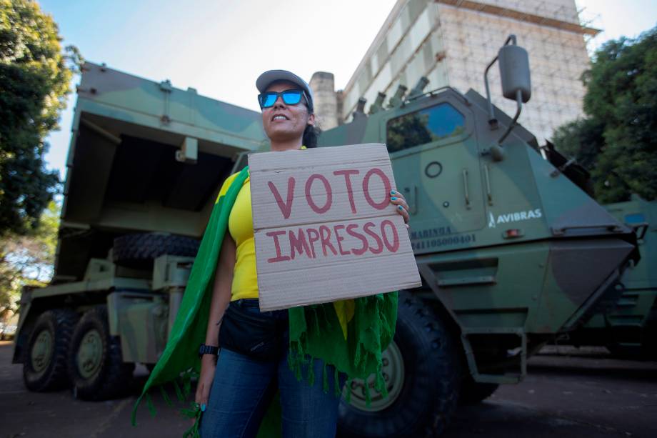 Apoiadora do presidente Jair Bolsonaro tira fotos ao lado dos tanques estacionados na Esplanada do Ministério -