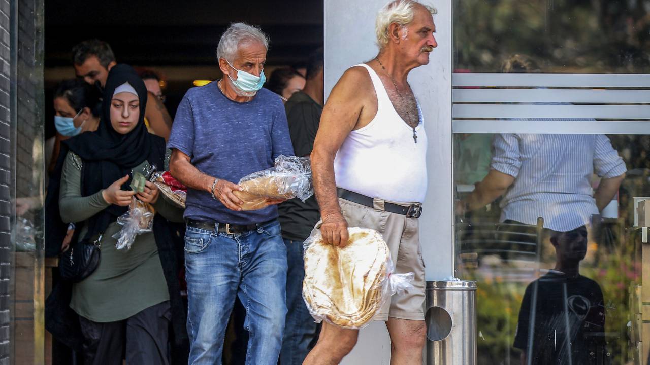 14 August 2021, Lebanon, Beirut: People walk out of a local bakery after grabbing packs of bread in the midst of severe fuel shortages and power cuts that is currently paralysing the country, amid one of the world's worst economic crisis in recent times. Photo: Marwan Naamani/dpa (Photo by Marwan Naamani/picture alliance via Getty Images)