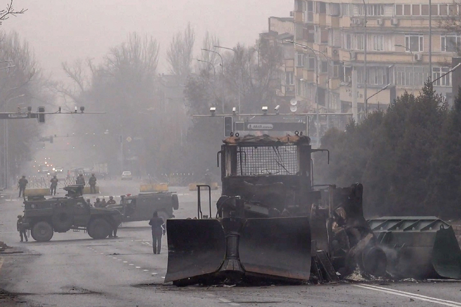 Servicemen and their military vehicles block a street in central Almaty on January 7, 2022, after violence that erupted following protests over hikes in fuel prices - Cazaquistão