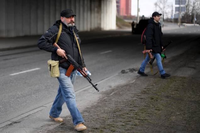 Voluntários, um segurando um fuzil AK-47, protegem uma estrada principal que leva a Kiev, na Ucrânia - Voluntários, um segurando um fuzil AK-47, protegem uma estrada principal que leva a Kiev, na Ucrânia -