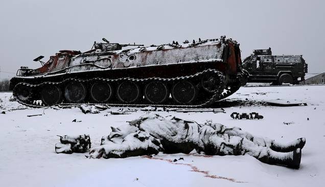 O corpo sem vida de um soldado é visto ao lado de um veículo blindado russo queimado depois que o exército ucraniano o atacou no dia anterior perto da cidade de Kharkiv, na Ucrânia - O corpo sem vida de um soldado é visto ao lado de um veículo blindado russo queimado depois que o exército ucraniano o atacou no dia anterior perto da cidade de Kharkiv, na Ucrânia -