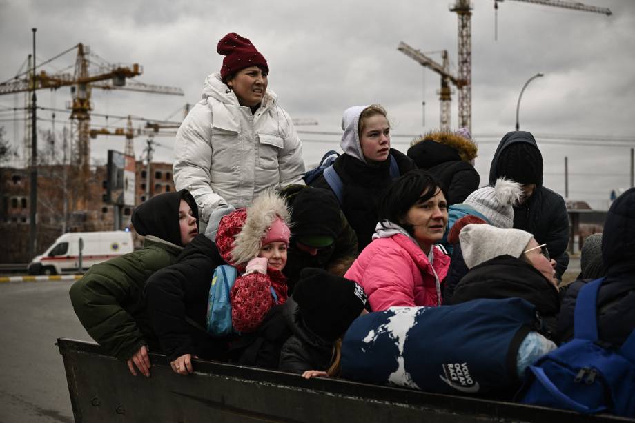 Uma criança observa moradores evacuando a cidade de Irpin durante bombardeios na Ucrânia -