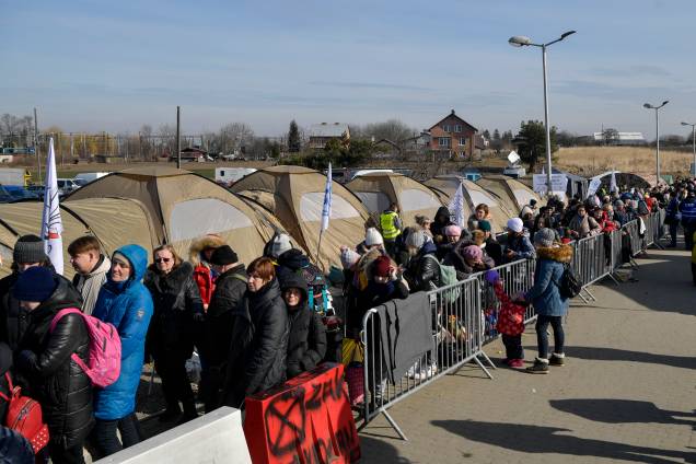 Refugiados fazem fila enquanto esperam por mais transporte na fronteira de Medyka - Refugiados fazem fila enquanto esperam por mais transporte na fronteira de Medyka -