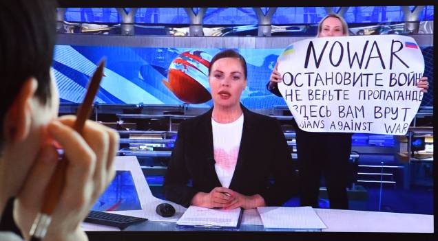 Um funcionário dissidente russo do Channel One entrar no estúdio de TV Ostankino durante o noticiário noturno mais assistido da Rússia, segurando um pôster que diz "Sem Guerra" e condenando a ação militar de Moscou na Ucrânia em Moscou Um funcionário dissidente russo do Channel One entrar no estúdio de TV Ostankino durante o noticiário noturno mais assistido da Rússia, segurando um pôster que diz "Sem Guerra" e condenando a ação militar de Moscou na Ucrânia em Moscou