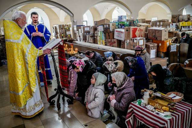 Membros da comunidade ucraniana durante um serviço pela paz na Ucrânia e vítimas de guerra em uma igreja católica ucraniana cheia de caixas de ajuda humanitária, em Berlim - Membros da comunidade ucraniana durante um serviço pela paz na Ucrânia e vítimas de guerra em uma igreja católica ucraniana cheia de caixas de ajuda humanitária, em Berlim -