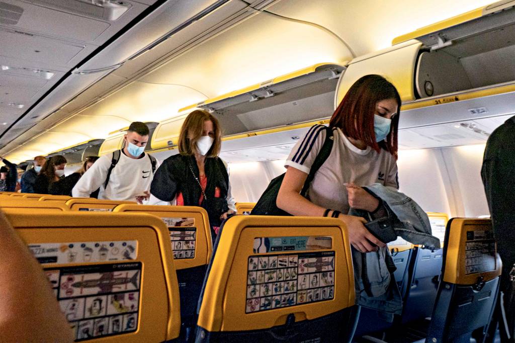 Ryanair Flight During The Covid-19 Pandemic Era Passengers during the flight wear a facemask in the cabin. Flying during the Covid-19 Coronavirus pandemic inside a Boeing 737-800 aircraft of Ryanair low cost carrier with destination Chania in Crete Island, a popular holiday destination. Inside the airplane is mandatory to wear face masks for the passengers and the flight crew, air stewardess etc while people need a negative COVID test to board on the plane as a safety measure, while the aviation and tourism industry is struggling to return back to normality. Greece is trying to boost its tourism and give privileges to vaccinated against Covid-19 pandemic international tourists and locals, as the country is heavily depended from the tourism industry. Chania Airport, Greece on June 13, 2021 (Photo by Nicolas Economou/NurPhoto via Getty Images)