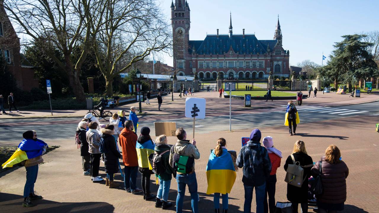 THE HAGUE NETHERLANDS - MARCH 7: Ukrainian nationals stand outside the International Criminal Court of Justice (ICJ) or Peace Palace on the first day of hearings on March 7, 2022 in The Hague The Netherlands. Ukraine is petitioning the ICJ to classify Russia's invasion as a genocide and issue an injunction under the UN Convention against Genocide. Photo by Michel Porro/Getty Images)