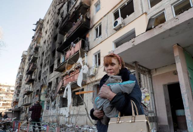 Uma mulher local carrega um gato ao deixar sua casa destruída após bombardeio em Kiev - Uma mulher local carrega um gato ao deixar sua casa destruída após bombardeio em Kiev -
