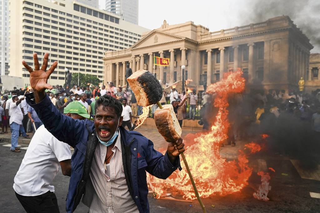 000_3268427.jpg ABAIXO A CARESTIA - Manifestante agita pão na frente do palácio do governo em Sri Lanka: revolta popular -
