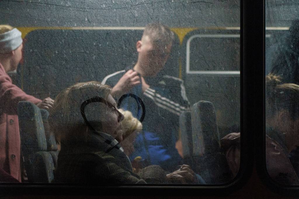 Passageiros aguardam enquanto um comboio de 30 &ocirc;nibus transportando refugiados de Mariupol e Melitopol chega ao centro de registro em Zaporizhzhia -