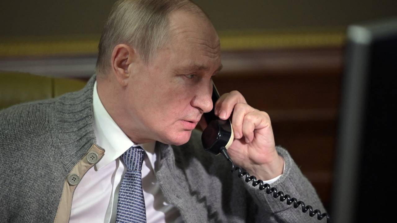 Russia's President Vladimir Putin speaks on the phone with participants of "The Christmas Tree Wishes" campaign in Strelna, outside St. Petersburg, on December 27, 2021. - The goal of the campaign is to make the New Year's dreams of orphans, children from low-income families, and disabled kids come true. (Photo by Alexey NIKOLSKY / SPUTNIK / AFP)