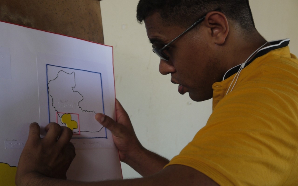 Pessoa com deficiência visual toca em um mapa