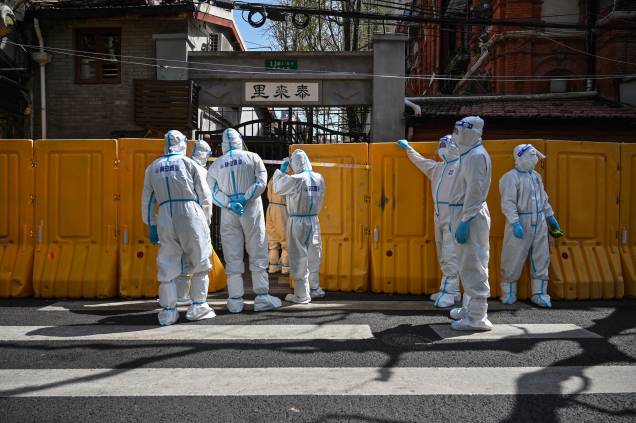 Trabalhadores do serviço público, que usam equipamentos de proteção, entregam vegetais`a moradores de um bairro confinado, no distrito de Jing'an, em Xangai. Trabalhadores do serviço público, que usam equipamentos de proteção, entregam vegetais`a moradores de um bairro confinado, no distrito de Jing'an, em Xangai.