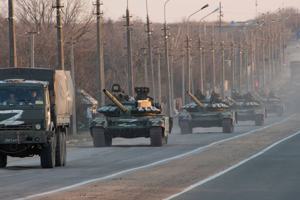 A column of tanks marked with the Z symbol stretches into MARIUPOL, UKRAINE - 2022/03/23: A column of tanks marked with the Z symbol stretches into the distance as they proceed northwards along the Mariupol-Donetsk highway. The battle between Russian / Pro Russian forces and the defencing Ukrainian forces lead by Azov battalion continues in the port city of Mariupol. (Photo by Maximilian Clarke/SOPA Images/LightRocket via Getty Images)