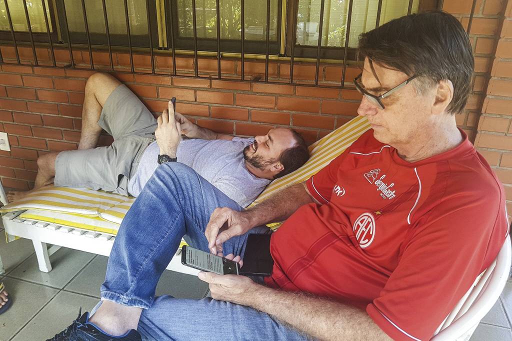 JAIR-BOLSONARO-CARLOS-BOLSONARO-CELULAR-2018-6544.jpg EM FAMÍLIA - Bolsonaro e o filho Carlos: canais da família no Telegram, somados, chegam a mais de 1,5 milhão de usuários -