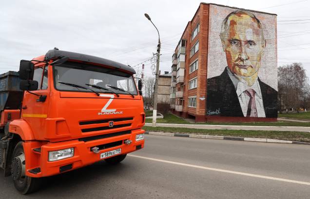 Um caminhão com a letra Z, percorre uma rua em frente a um bloco de apartamentos com um mural representando o presidente russo Vladimir Putin na cidade de Kashira, Rússia, 20 de abril de 2022. Um caminhão com a letra Z, percorre uma rua em frente a um bloco de apartamentos com um mural representando o presidente russo Vladimir Putin na cidade de Kashira, Rússia, 20 de abril de 2022.