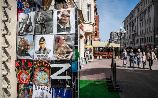 Russos andam na rua e`a frente loja de presentes com camisetas à venda com a letra Z e retratos do presidente russo Vladimir Putin em Moscou, Rússia, 18 de abril de 2022. Russos andam na rua e`a frente loja de presentes com camisetas à venda com a letra Z e retratos do presidente russo Vladimir Putin em Moscou, Rússia, 18 de abril de 2022.