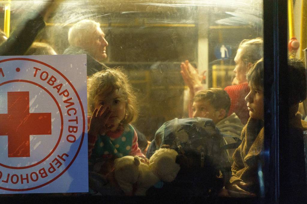 Uma crian&ccedil;a olha pela janela de um &ocirc;nibus enquanto um comboio de 30 &ocirc;nibus transportando refugiados de Mariupol e Melitopol chega ao centro de Zaporizhzhia -