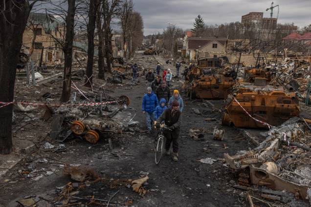 Moradores passam por máquinas militares russas destruídas na rua, em Bucha - Moradores passam por máquinas militares russas destruídas na rua, em Bucha -