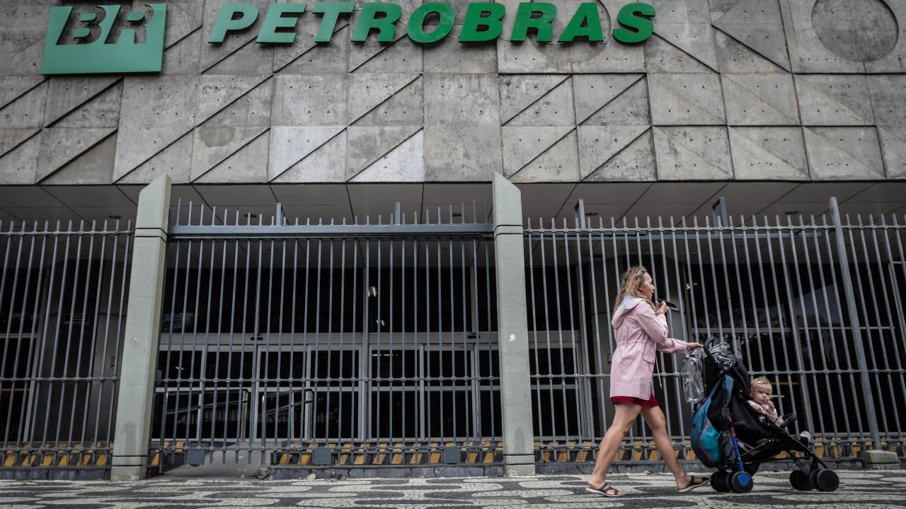 AME8929. RÍO DE JANEIRO (BRASIL), 12/05/2022.- Una mujer pasa hoy con su bebé frente al edificio de la empresa estatal Petróleo Brasileiro S.A. (Petrobras), en Río de Janeiro (Brasil). El nuevo ministro de Energía de Brasil, Adolfo Sachsida, ha expresado su intención de avanzar hacia la privatización de la petrolera Petrobras, un anuncio de impacto en un año en que el presidente Jair Bolsonaro aspira a su reelección. EFE/André Coelho