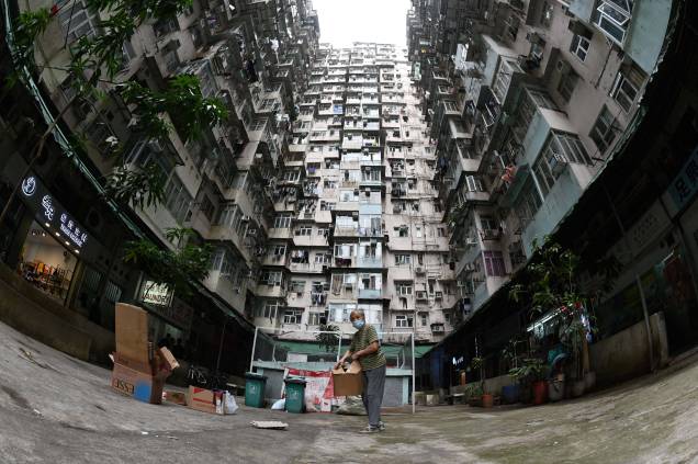 Foto tirada em 22 de março de 2022, mostra uma mulher coletando papelão em um conjunto habitacional em Hong Kong. Foto tirada em 22 de março de 2022, mostra uma mulher coletando papelão em um conjunto habitacional em Hong Kong.