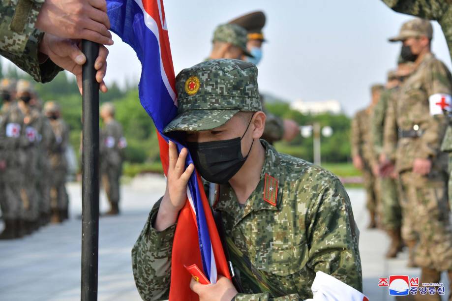 Soldados norte-coreanos reunidos para prometer cumprir sua missão de fornecer medicamentos às farmácias em meio à campanha antiepidêmica do país; no Ministério da Defesa Nacional em Pyongyang, Coreia do Norte, 16 de maio de 2022.