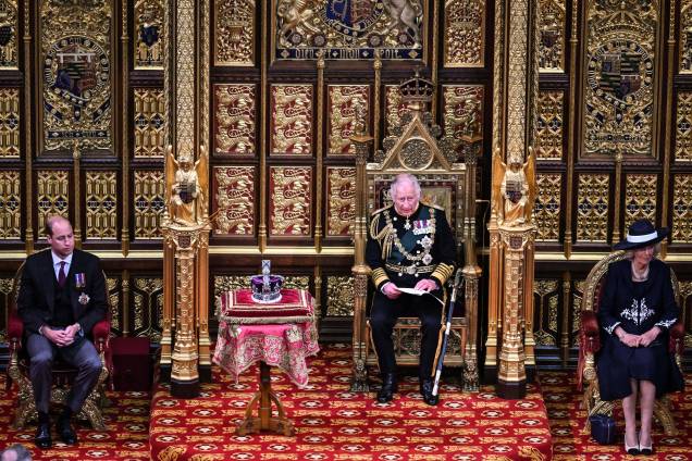 O príncipe britânico Charles, Príncipe de Gales, lê o Discurso da Rainha sentado ao lado da Coroa do Estado Imperial da Grã-Bretanha, Camilla Duquesa da Cornualha e do Britânico Príncipe William, Duque de Cambridge na Câmara dos Lordes, durante a Abertura Estadual do Parlamento, em Londres, em 10 de maio de 2022. O príncipe britânico Charles, Príncipe de Gales, lê o Discurso da Rainha sentado ao lado da Coroa do Estado Imperial da Grã-Bretanha, Camilla Duquesa da Cornualha e do Britânico Príncipe William, Duque de Cambridge na Câmara dos Lordes, durante a Abertura Estadual do Parlamento, em Londres, em 10 de maio de 2022.