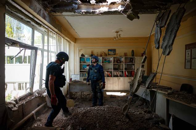 Membros de uma equipe do Serviço de Emergência do Estado da Ucrânia verificam se há dispositivos não detonados em um prédio escolar após o bombardeio russo em Kharkiv, leste da Ucrânia, em 28 de abril de 2022. Membros de uma equipe do Serviço de Emergência do Estado da Ucrânia verificam se há dispositivos não detonados em um prédio escolar após o bombardeio russo em Kharkiv, leste da Ucrânia, em 28 de abril de 2022.