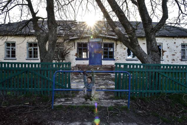 Menino brinca em frente a uma escola na vila de Lukashivka, região de Chernihiv, 27 de abril de 2022. Em 24 de fevereiro, tropas russas entraram no território ucraniano no que o presidente russo declarou uma 'operação militar especial', resultando em combates e destruição no país, um enorme fluxo de refugiados e múltiplas sanções contra a Rússia. Menino brinca em frente a uma escola na vila de Lukashivka, região de Chernihiv, 27 de abril de 2022. Em 24 de fevereiro, tropas russas entraram no território ucraniano no que o presidente russo declarou uma 'operação militar especial', resultando em combates e destruição no país, um enorme fluxo de refugiados e múltiplas sanções contra a Rússia.