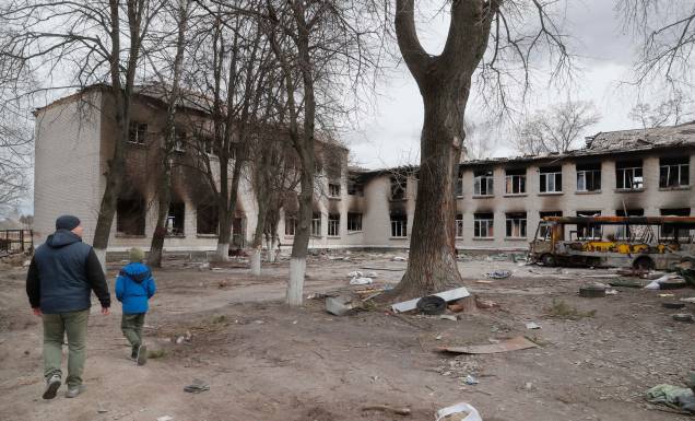 Um morador local com seu filho observa uma escola danificada que era uma base de tropas russas na aldeia de Bohdanivka, não muito longe de Brovary, região de Kiev, Ucrânia, 12 de abril de 2022. As tropas russas entraram na Ucrânia em 24 de fevereiro, resultando em combates e destruição no país e desencadeando uma série de severas sanções econômicas à Rússia por parte dos países ocidentais. Um morador local com seu filho observa uma escola danificada que era uma base de tropas russas na aldeia de Bohdanivka, não muito longe de Brovary, região de Kiev, Ucrânia, 12 de abril de 2022. As tropas russas entraram na Ucrânia em 24 de fevereiro, resultando em combates e destruição no país e desencadeando uma série de severas sanções econômicas à Rússia por parte dos países ocidentais.
