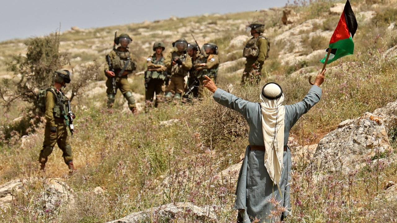 TOPSHOT - Members of Israeli security forces deploy as Palestinians demonstrate against the establishment of Israeli outposts on their lands, in Beit Dajan east of Nablus in the occupied West Bank, on April 29, 2022. (Photo by JAAFAR ASHTIYEH / AFP)