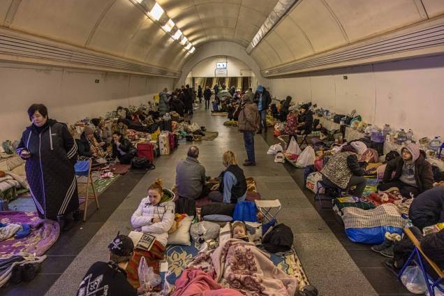 Pessoas dentro da estação de metrô Dorohozhychi, transformada em abrigo antiaéreo, em Kiev, Ucrânia. Pessoas dentro da estação de metrô Dorohozhychi, transformada em abrigo antiaéreo, em Kiev, Ucrânia.