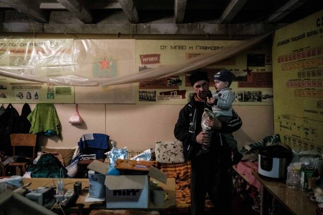 Vitalii (50 anos), segura seu filho Kiril, 2 anos, no bunker da fábrica Ostchem em Severodonetsk, leste da Ucrânia, em 27 de abril de 2022, em meio à invasão dos russos. Vitalii (50 anos), segura seu filho Kiril, 2 anos, no bunker da fábrica Ostchem em Severodonetsk, leste da Ucrânia, em 27 de abril de 2022, em meio à invasão dos russos.