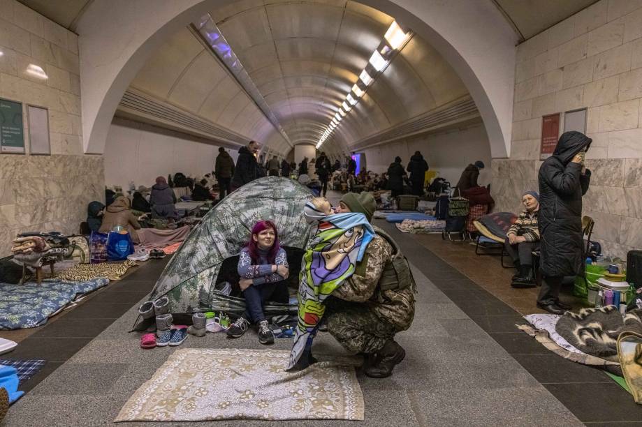 Um militar ucraniano abraça seu filho na estação de metrô Dorohozhychi, que é usada como abrigo antiaéreo em Kiev, Ucrânia, em 15 de maio de 2022.