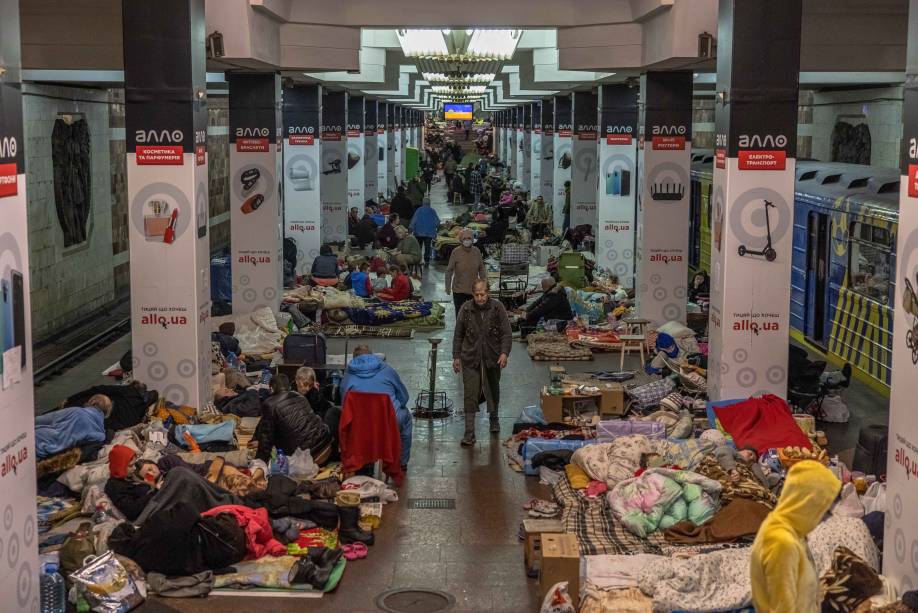 Pessoas dentro de uma estação de metrô usada como abrigo antiaéreo, enquanto o ataque da Rússia à Ucrânia continua, em Kharkiv, nordeste da Ucrânia.