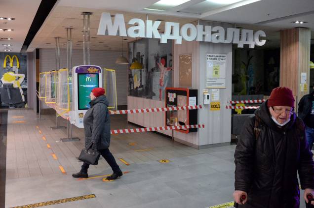 16/03/2022, pessoas caminham ao lado de um restaurante McDonald's fechado em um shopping center em Moscou. 16/03/2022, pessoas caminham ao lado de um restaurante McDonald's fechado em um shopping center em Moscou.
