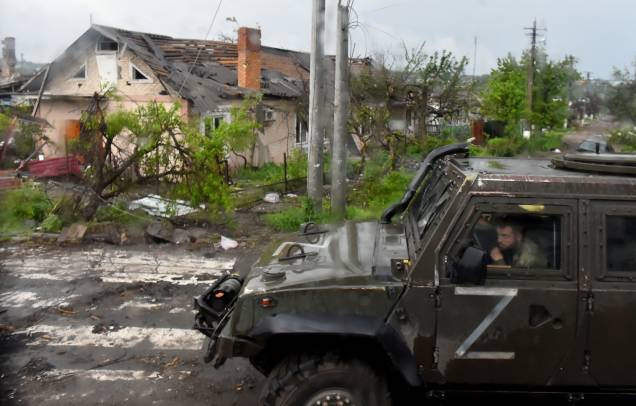 Um veículo militar russo pintado com a letra Z passa por casas destruídas na cidade portuária de Mariupol, na Ucrânia, em 18/05/2022, em meio à dominação militar russa em andamento na Ucrânia. Um veículo militar russo pintado com a letra Z passa por casas destruídas na cidade portuária de Mariupol, na Ucrânia, em 18/05/2022, em meio à dominação militar russa em andamento na Ucrânia.