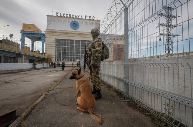 Um soldado russo e um cão de guarda perto da Usina Hidrelétrica Kakhovka no rio Dnieper em Kakhovka, próximo de Kherson, Ucrânia, em 20 de maio de 2022. Um soldado russo e um cão de guarda perto da Usina Hidrelétrica Kakhovka no rio Dnieper em Kakhovka, próximo de Kherson, Ucrânia, em 20 de maio de 2022.