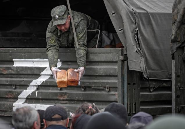Dominada pelos soldados russos, militares distribuem pães como ajuda humanitária para a população local em Mariupol, Ucrânia, 12/05/2022. Dominada pelos soldados russos, militares distribuem pães como ajuda humanitária para a população local em Mariupol, Ucrânia, 12/05/2022.