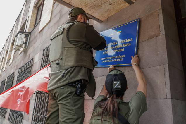 Igor Zakharevich, prefeito de Debaltseve nomeado por militantes russos, remove a placa ucraniana do prédio da administração de Svitlodarsk, região de Donetsk, Ucrânia, 26/05/2022. Igor Zakharevich, prefeito de Debaltseve nomeado por militantes russos, remove a placa ucraniana do prédio da administração de Svitlodarsk, região de Donetsk, Ucrânia, 26/05/2022.