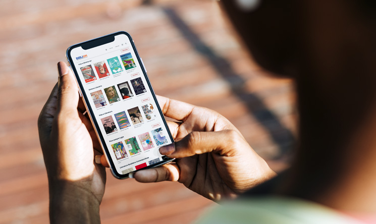 Uma pessoa segura celular com a tela aberta na plataforma digital BibliON, uma biblioteca pública virtual