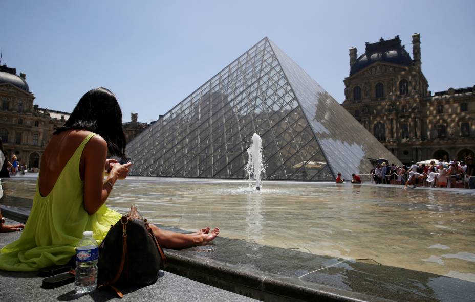 Um banhista senta-se na borda da fonte da Pirâmide do Louvre, em Paris, em 17/06/2022, enquanto uma onda de calor varre grande parte da França e da Europa. Um banhista senta-se na borda da fonte da Pirâmide do Louvre, em Paris, em 17/06/2022, enquanto uma onda de calor varre grande parte da França e da Europa.